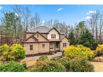 Charming two-story brick home with well-maintained landscaping and a welcoming front entrance at 1030 Chateau Forest Rd, Hoschton, GA 30548