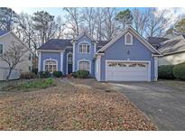 Charming blue two-story home with attached two-car garage and well-maintained landscaping at 2910 Mitchell Ne Cv, Brookhaven, GA 30319