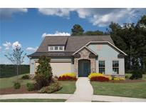 Charming single-Gathering home with stone accents, blue siding, a well-manicured lawn, and flowerbeds at 2446 Naples St, Hoschton, GA 30548