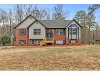 Charming two-story home with a combination of brick and gray siding, complemented by black shutters and a well-manicured lawn at 161 Kingswood Dr, Ellenwood, GA 30294
