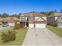 Charming two-story home featuring a brick facade, a two-car garage, and a well-manicured front yard at 2592 Jacanar Sw Ln, Atlanta, GA 30331