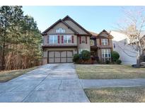 Charming two-story home with a manicured lawn, two-car garage and lovely architectural details at 460 Chandler Bluff Ct, Grayson, GA 30017