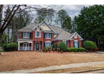 Charming two-story brick home featuring manicured landscaping and a welcoming front porch at 1159 Bowerie Chase, Powder Springs, GA 30127