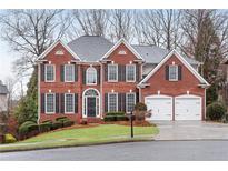 Beautiful brick home with manicured lawn, two car garage, and classic architectural details at 1900 Sanborne Way, Dacula, GA 30019