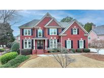 Beautiful brick home featuring a manicured lawn and traditional architectural details at 370 Laurel Oak Dr, Suwanee, GA 30024