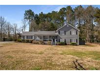 Charming two-story home with gray siding, black shutters, and a welcoming front porch at 2920 Glenda Ct, Loganville, GA 30052