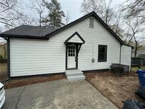 Charming home exterior features white siding, black trim and a welcoming front entry way at 1691 Flat Shoals Se Rd, Atlanta, GA 30316