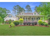 Charming home featuring a welcoming front porch and lush landscaping at 1870 Shoreline Trce, Grayson, GA 30017