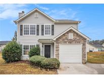 Charming two-story home with gray siding, black shutters, and stone accents around the garage at 4872 Antelope Cv, Atlanta, GA 30349