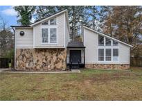 Charming home showcasing stone accents, a well-manicured lawn and striking architectural details at 5444 Wylstream, Norcross, GA 30093