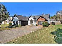 Charming single-story home boasting a manicured front yard and attached two-car garage at 690 Avalon Forest Dr, Lawrenceville, GA 30044