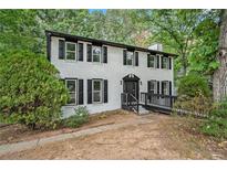 Charming two-story home with black shutters, white brick and a well-manicured front lawn at 3333 Devaughn Ne Dr, Marietta, GA 30066