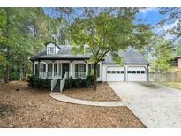 Charming home featuring a two-car garage, white picket fence, and well-manicured lawn at 372 Rustic Ridge Cir, Lawrenceville, GA 30043