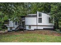 Unique home design with modern black trim, clean white siding, and a woodsy surrounding at 336 Rockmoor Trl, Marietta, GA 30066