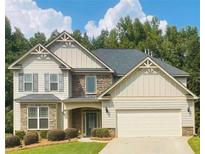 Charming two-story home featuring a manicured lawn, stone accents, and an attached two-car garage at 4357 Kershaw Dr, Snellville, GA 30039