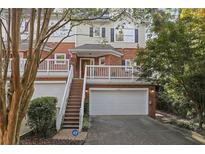 Charming townhouse with brick facade, front balcony, and two-car garage at 8540 Hope Mews Ct, Atlanta, GA 30350