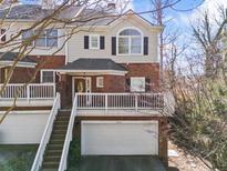 Charming two-story townhome featuring a brick facade, white trim, and a well-maintained garage at 8540 Hope Mews Ct, Atlanta, GA 30350