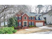 Beautiful two-story brick home with manicured landscaping and a welcoming entrance at 10815 Donamere Dr, Johns Creek, GA 30022