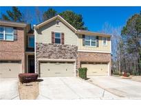 Charming townhome featuring a stone facade and attached garages in a well-maintained community at 209 Townview Dr, Woodstock, GA 30189