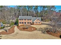 Stunning two-story brick home with a well-manicured front yard and mature trees at 2805 Roxburgh Dr, Roswell, GA 30076