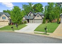 Charming two-story home featuring a well-manicured lawn and a three-car garage at 1605 Camden Cove Dr, Cumming, GA 30040