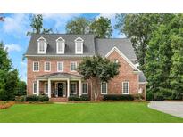 Charming two-story brick home with a manicured lawn and a welcoming front porch at 4992 Price Dr, Suwanee, GA 30024