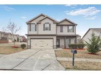 Charming two-story home with a two-car garage and a well-maintained front yard, offering great curb appeal at 825 Donington Cir, Lawrenceville, GA 30045