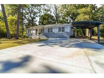 Charming single-story home with a long driveway and carport, nestled among mature trees at 1652 Pine Cir, Austell, GA 30168