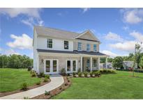Charming two-story home with a brick and siding exterior, a manicured lawn and a welcoming front porch at 371 Foxglove Way, Mcdonough, GA 30253