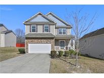 Charming two-story home featuring a stone-accented front, attached garage, and inviting front porch at 1566 Wilson Manor Cir, Lawrenceville, GA 30045