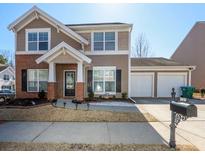 Charming two-story home with brick and siding exterior, well-maintained landscaping, and a two-car garage at 1201 Red Bud Ln, Canton, GA 30114