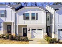 Charming townhome featuring a one-car garage and a well-maintained front yard at 5652 Plain Field Ln, Lilburn, GA 30047