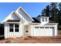 New construction home with white siding, black roof, and an attached garage and unfinished yard at 156 Easton Park Blvd, Dallas, GA 30157