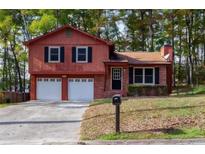 Charming two-story home with a two-car garage and a well-maintained front yard at 3867 Cherie Glen Rd, Snellville, GA 30039