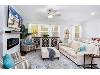 Bright living room with a fireplace, ceiling fan, and plenty of natural light at 269 Whitetail Cir, Canton, GA 30115