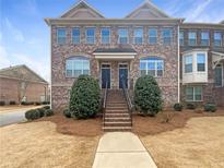 Charming brick townhome featuring a symmetrical design, well-maintained landscaping, and inviting front entrance at 4954 Wyeth Way, Alpharetta, GA 30022