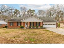 Charming brick home featuring an attached garage and a well-manicured front yard at 3261 Hidden Forest Dr, Snellville, GA 30078