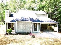 Charming single-Gathering home with a welcoming front yard and convenient carport at 215 Carmichael Rd, Woodstock, GA 30189