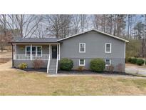 Charming two-story home featuring gray siding, a cozy front porch and well-maintained landscaping at 3310 Forest Creek Sw Dr, Marietta, GA 30064