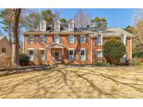Traditional red brick home with dormer windows and manicured lawn at 656 Gunby Se Rd, Marietta, GA 30067