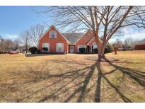 Charming brick home featuring manicured landscaping, classic shutters, and a welcoming front entrance at 1500 Elena Dr, Mcdonough, GA 30253