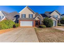 Charming two-story home with a two-car garage and manicured front lawn at 527 Carlton Pointe Dr, Palmetto, GA 30268