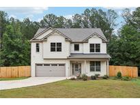 Charming two-story home with attached garage and beautifully landscaped front yard at 1511 New Hope Rd, Locust Grove, GA 30248