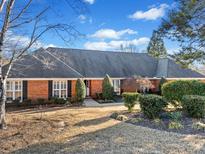 Charming red brick home with a well-manicured lawn and lush landscaping, perfect for curb appeal at 290 Connemara Ne Dr, Marietta, GA 30067