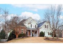 Charming two-story home featuring a brick facade, light green siding, and a welcoming front porch at 1213 Fairwinds Dr, Loganville, GA 30052