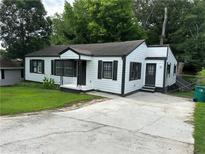 Charming single-story home with white siding, black trim, and well-maintained front yard at 1298 Belmont Se Ave, Smyrna, GA 30080