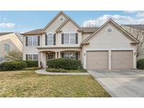 Charming two-story home featuring a manicured lawn and a two-car garage at 1307 Calderwood Se Ct, Smyrna, GA 30080