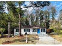 Charming single-story home featuring a blue front door, fresh landscaping, and a driveway at 2745 Marco Nw Dr, Atlanta, GA 30318