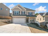 Charming two-story home with brick accents, two-car garage and manicured front yard under a bright blue sky at 431 Crestmont Ln, Canton, GA 30114