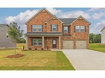 Charming two-story brick home with a well-manicured lawn and attached two-car garage at 1590 Sungrown Way, Mcdonough, GA 30253